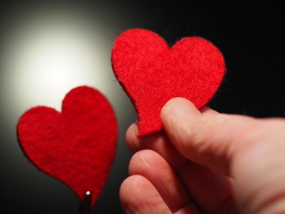 Hand die zwei rote Filzherzen hält